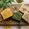 Handcrafted Nishkalmasha herbal soaps with neem, turmeric, and fermented rice water on a wooden slab.