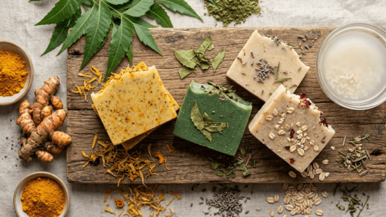 Handcrafted Nishkalmasha herbal soaps with neem, turmeric, and fermented rice water on a wooden slab.